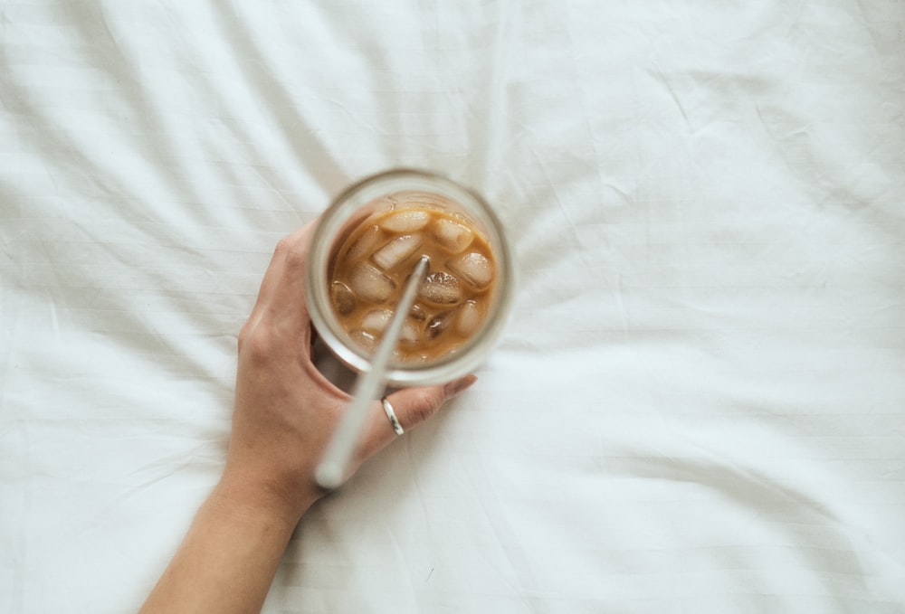 person holding white ceramic mug with coffee