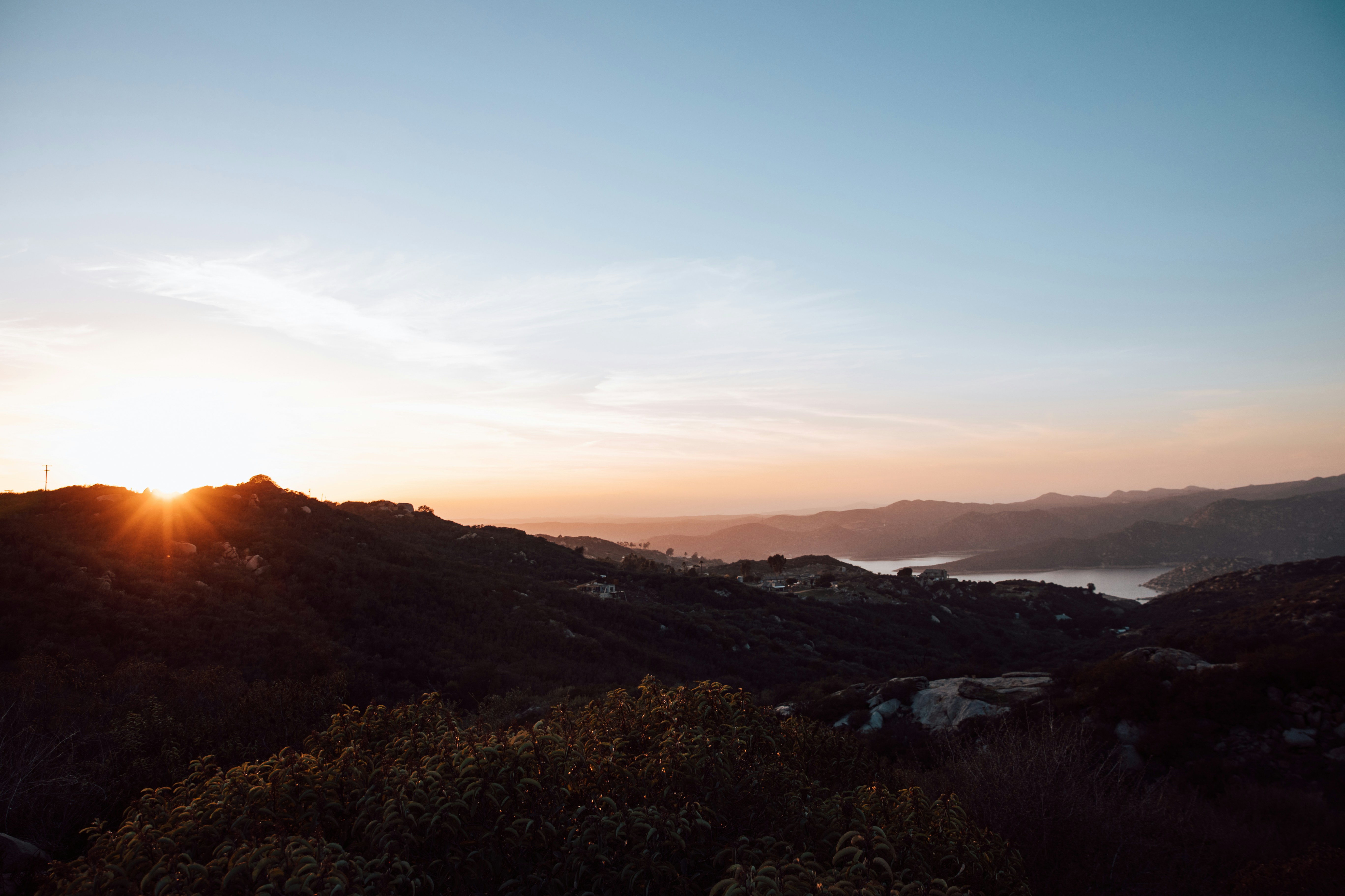 green trees and mountains during sunset