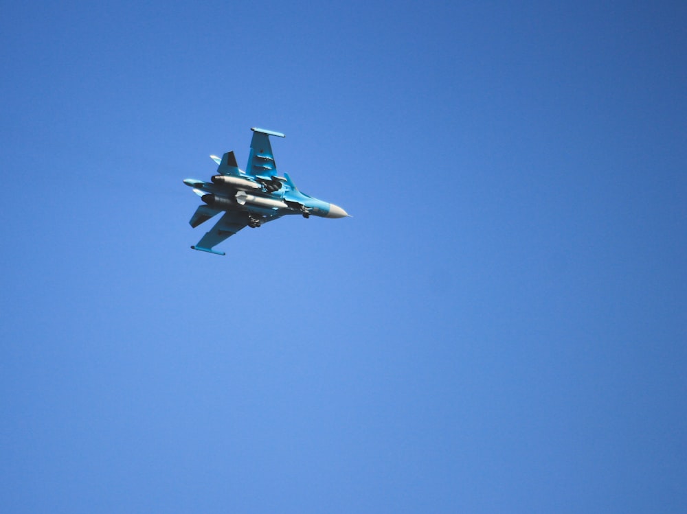 white and blue jet plane in mid air during daytime