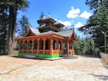 A serene temple surrounded by tall pine trees in Dharamshala.