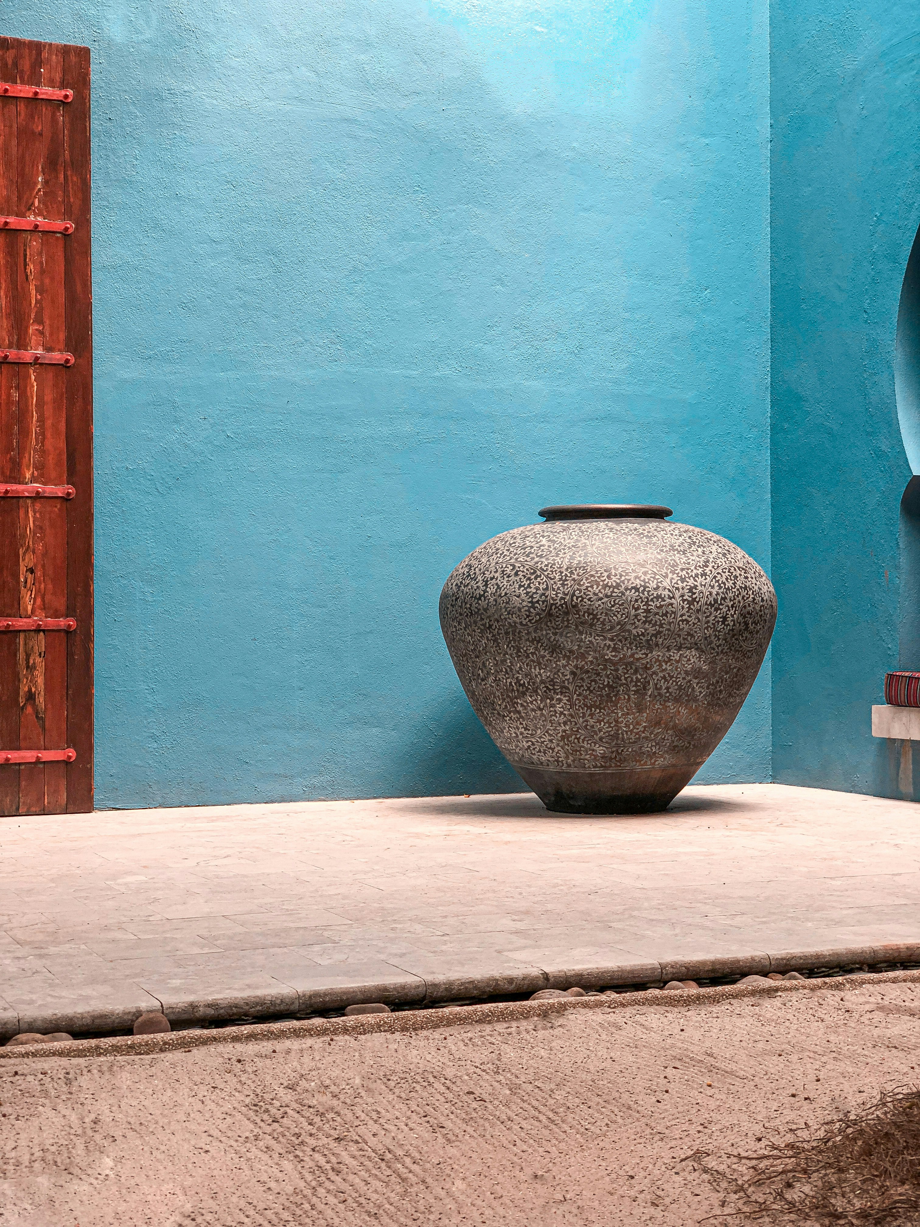 brown clay vase on white concrete surface