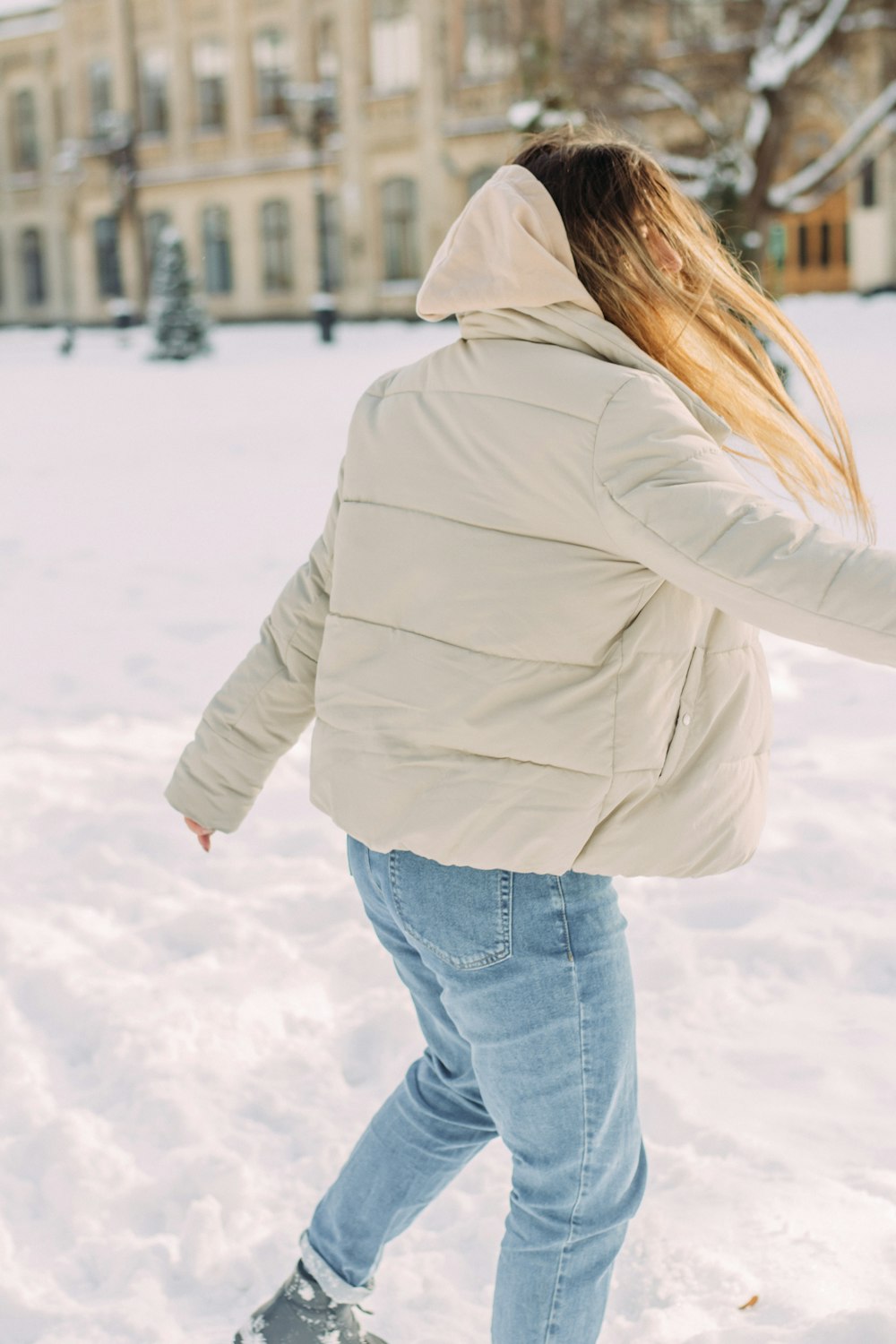 woman in white jacket and blue denim jeans standing on snow covered ground  during daytime photo – Free Grey Image on Unsplash