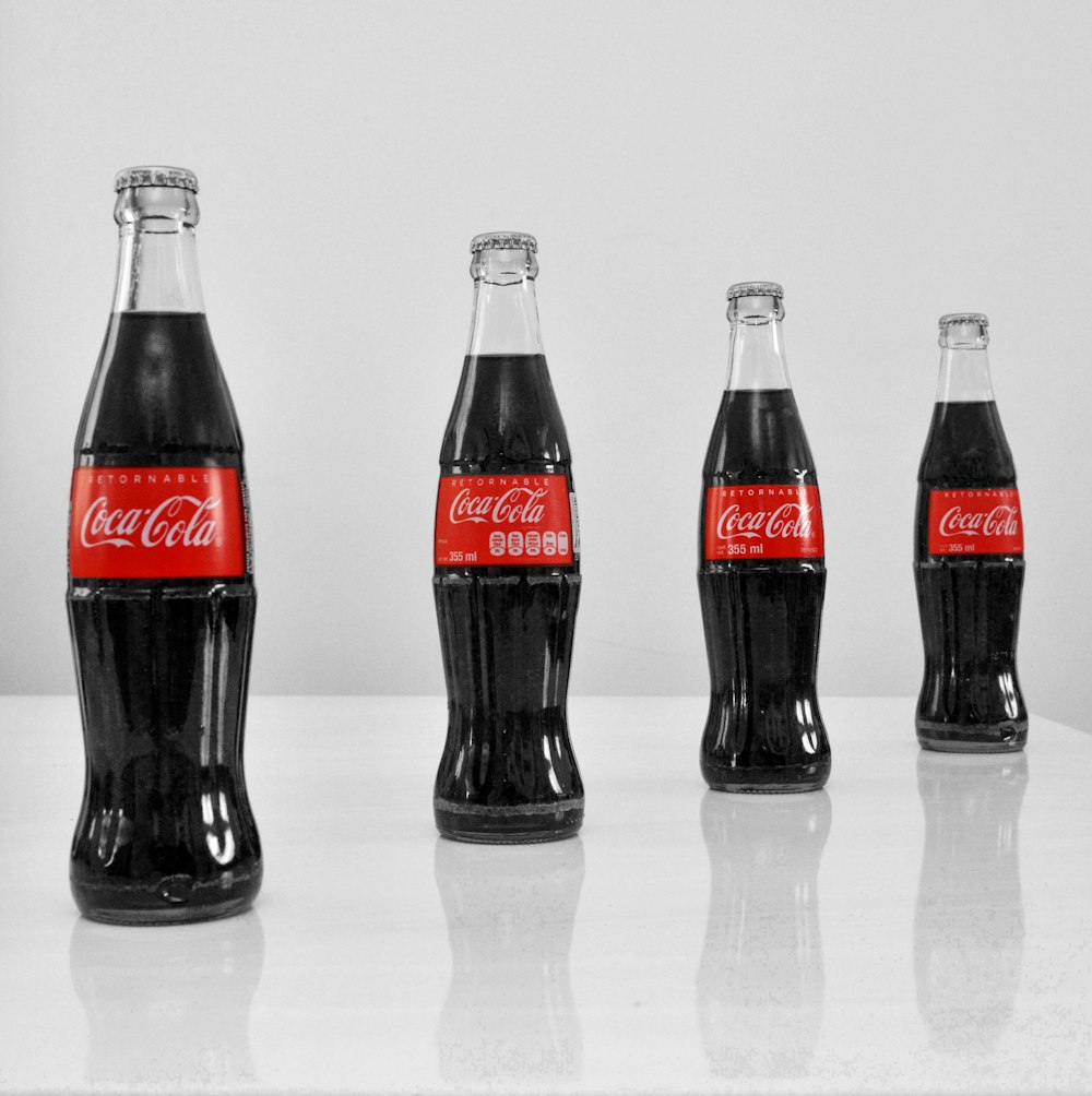 coca cola glass bottles on white table