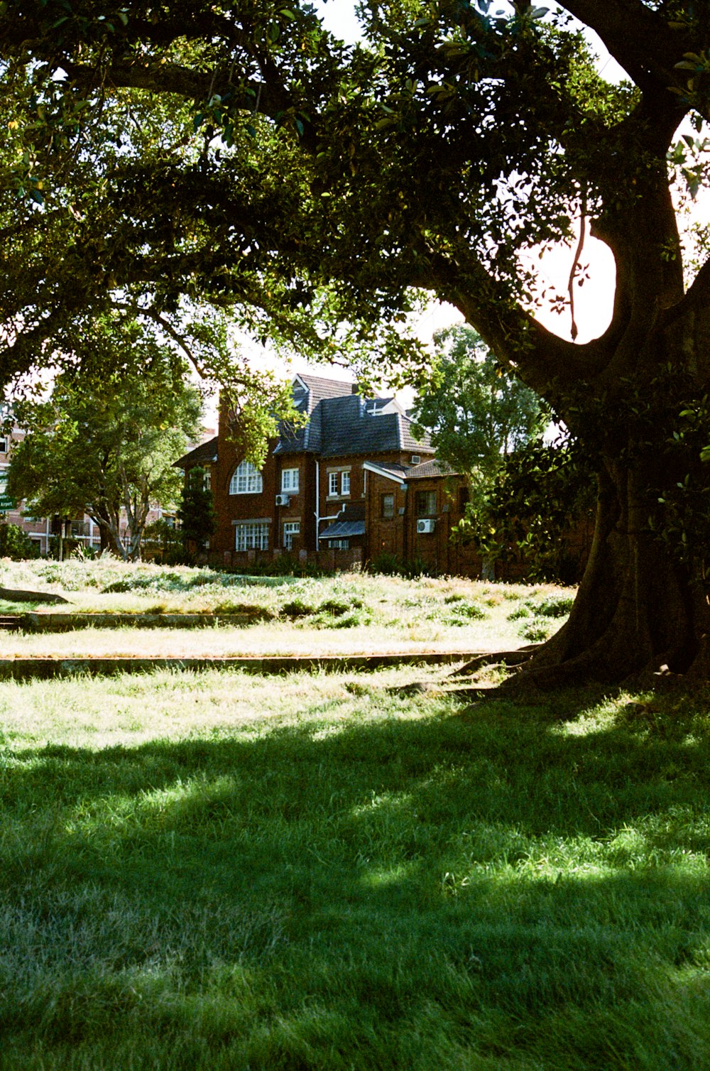 brown and white house near green grass field during daytime