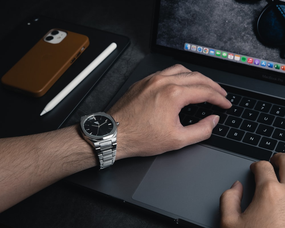 person wearing silver round analog watch