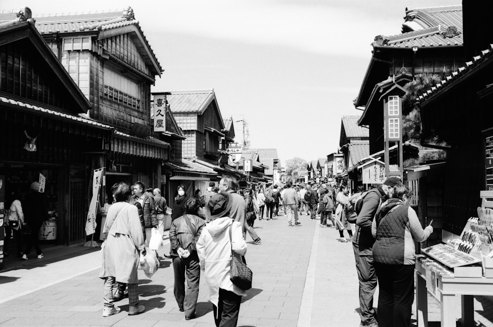 people walking on street in grayscale photography