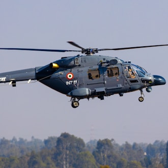 black and yellow helicopter flying over green trees during daytime