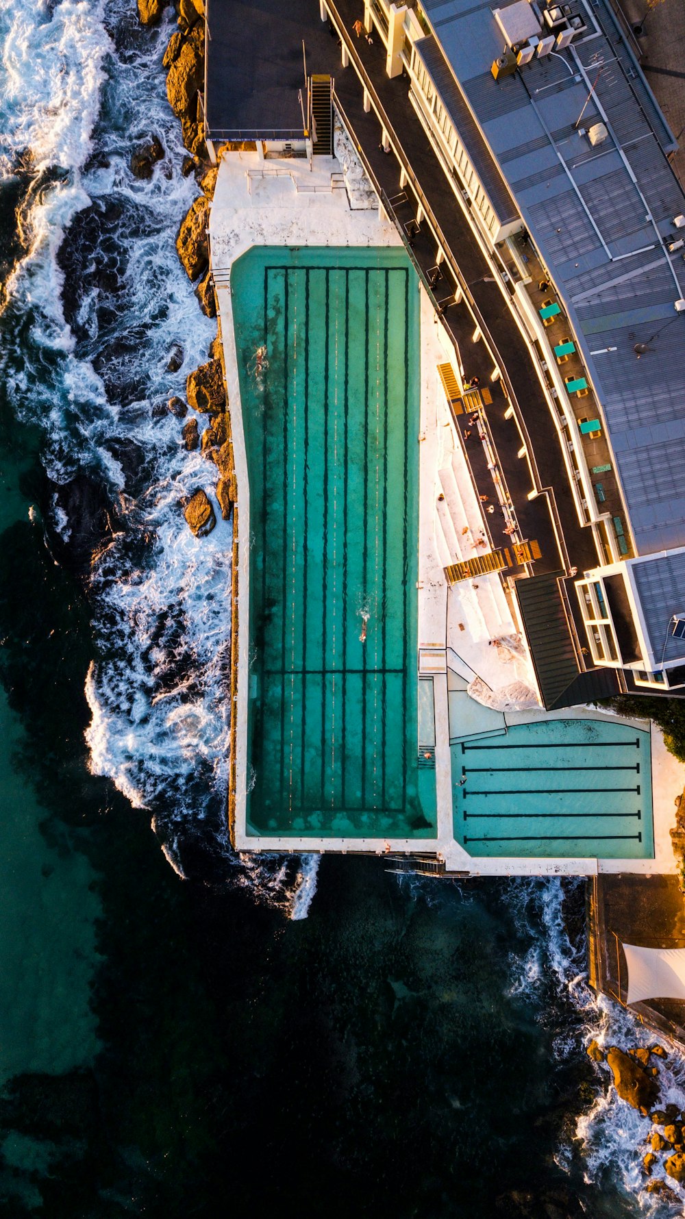 aerial view of white and blue building beside body of water during daytime