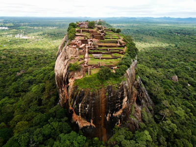Aerial view of the Sigiriya rock fortress rising above a dense green forest