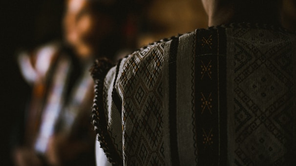 Close-up of a Bamenda traditional dress fabric showing rich textures and bold colors under natural light.