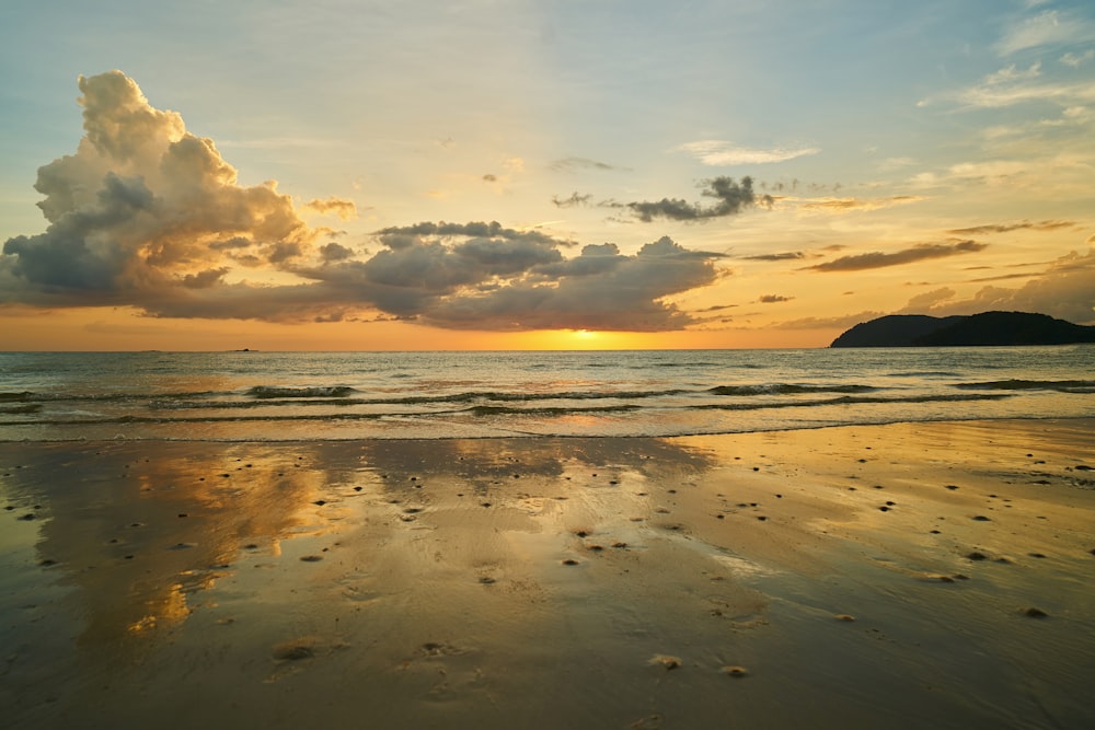 body of water under cloudy sky during sunset