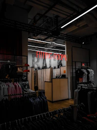 a clothing store with a neon sign above it