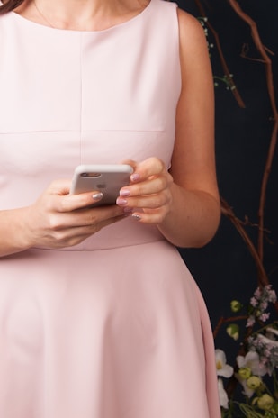 woman in white sleeveless dress holding silver iphone 6