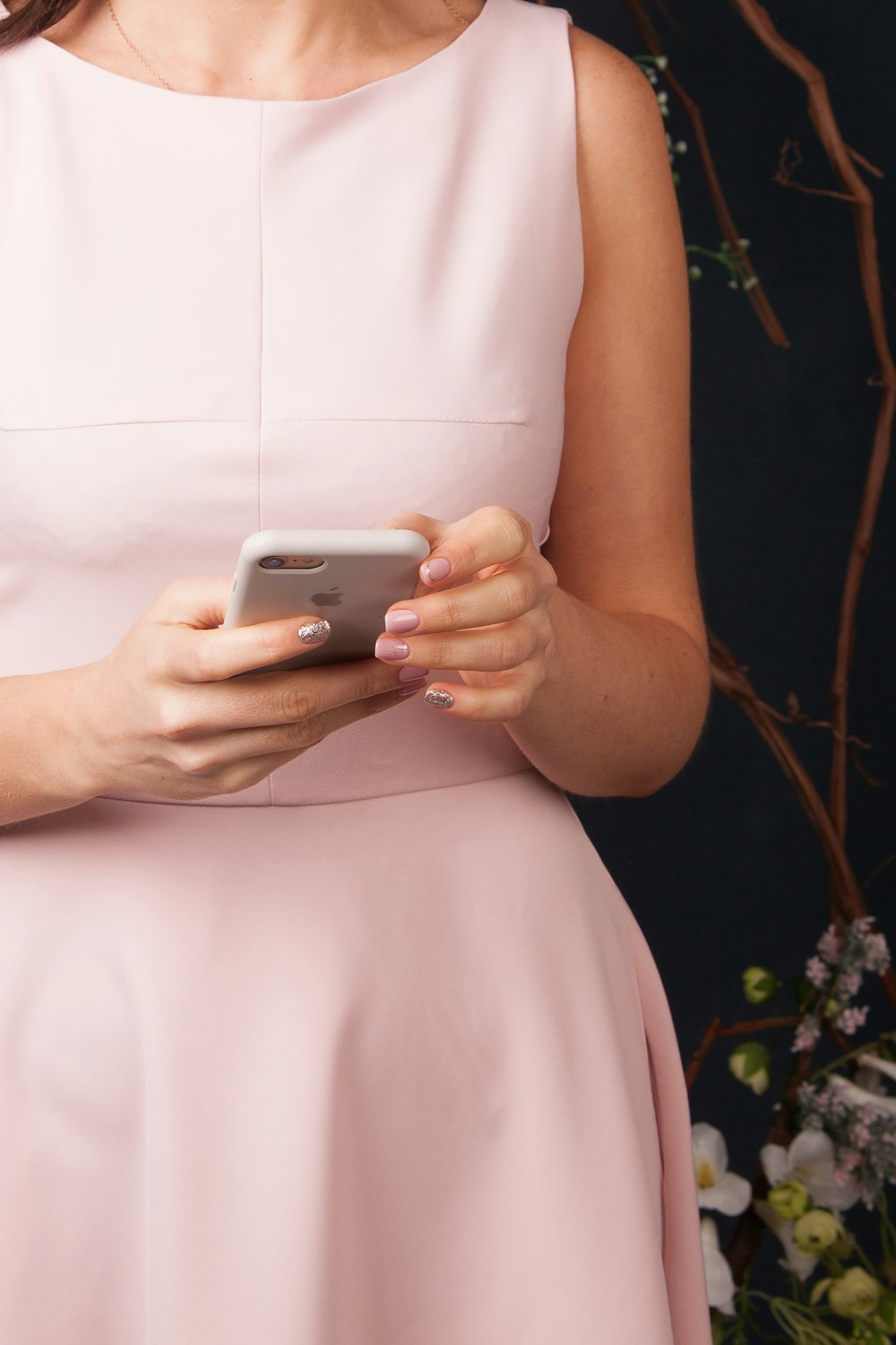 woman in white sleeveless dress holding silver iphone 6