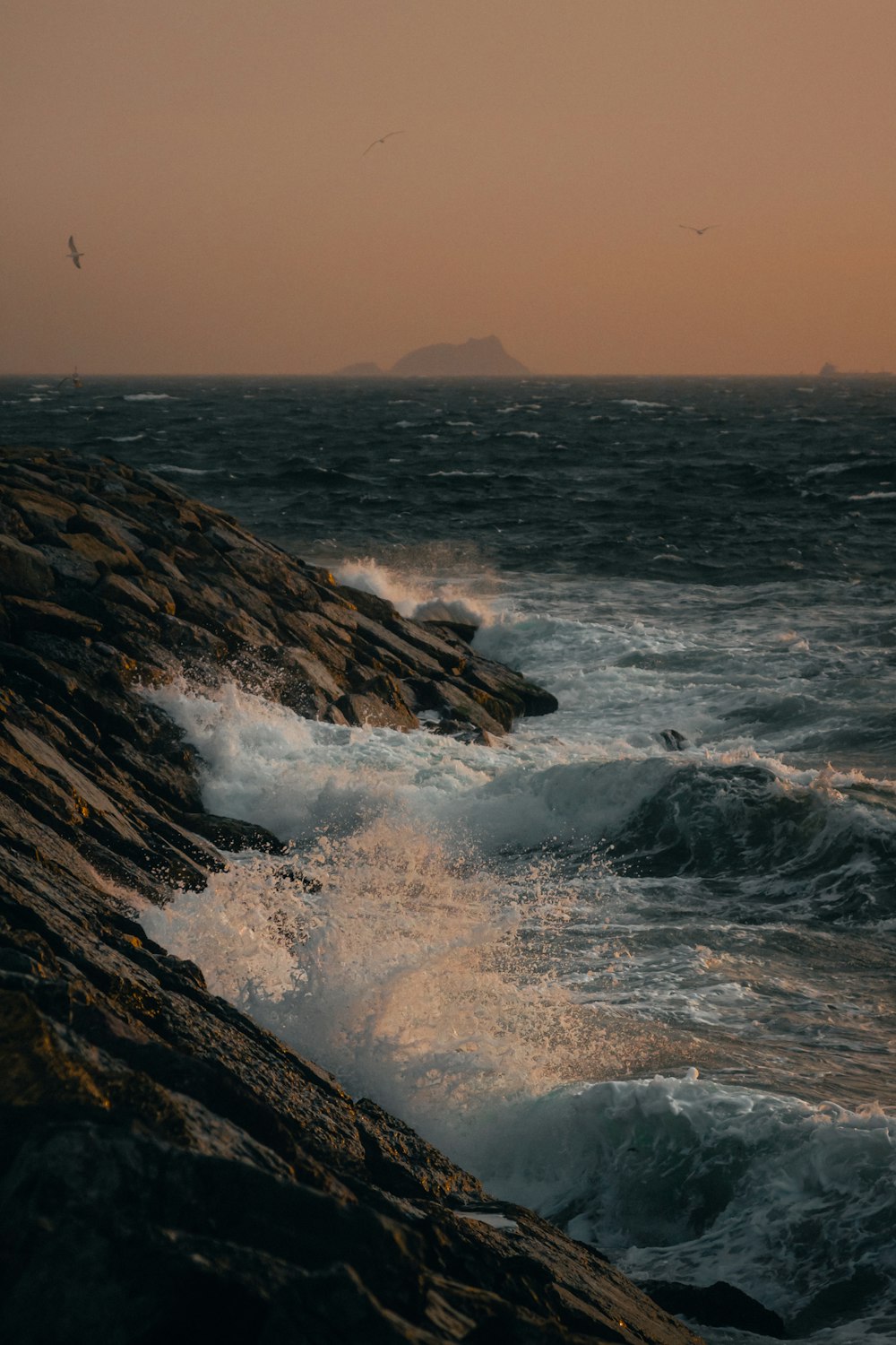 ocean waves crashing on rocky shore during daytime