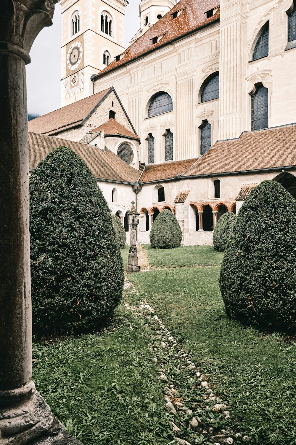 Champ d’herbe verte près d’un bâtiment en béton brun pendant la journée