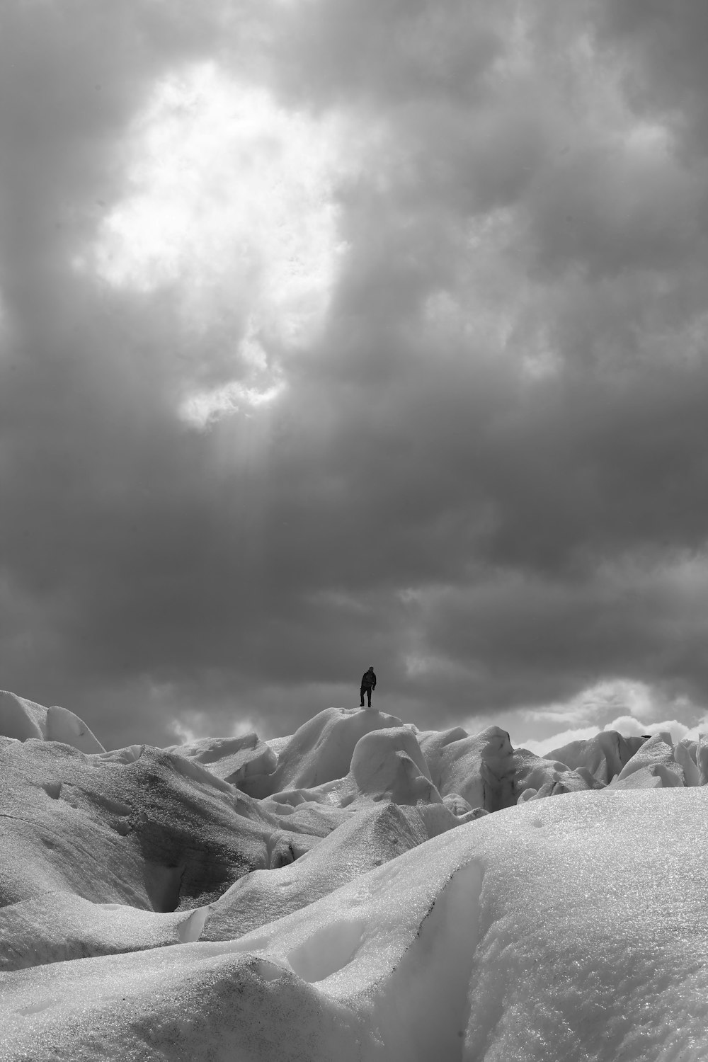 grayscale photo of people on top of mountain