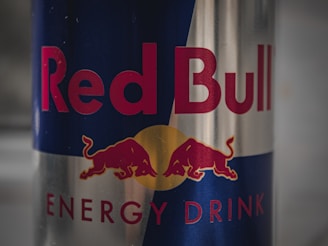 A detailed image of a Red Bull can opener ring displayed on a wooden surface.