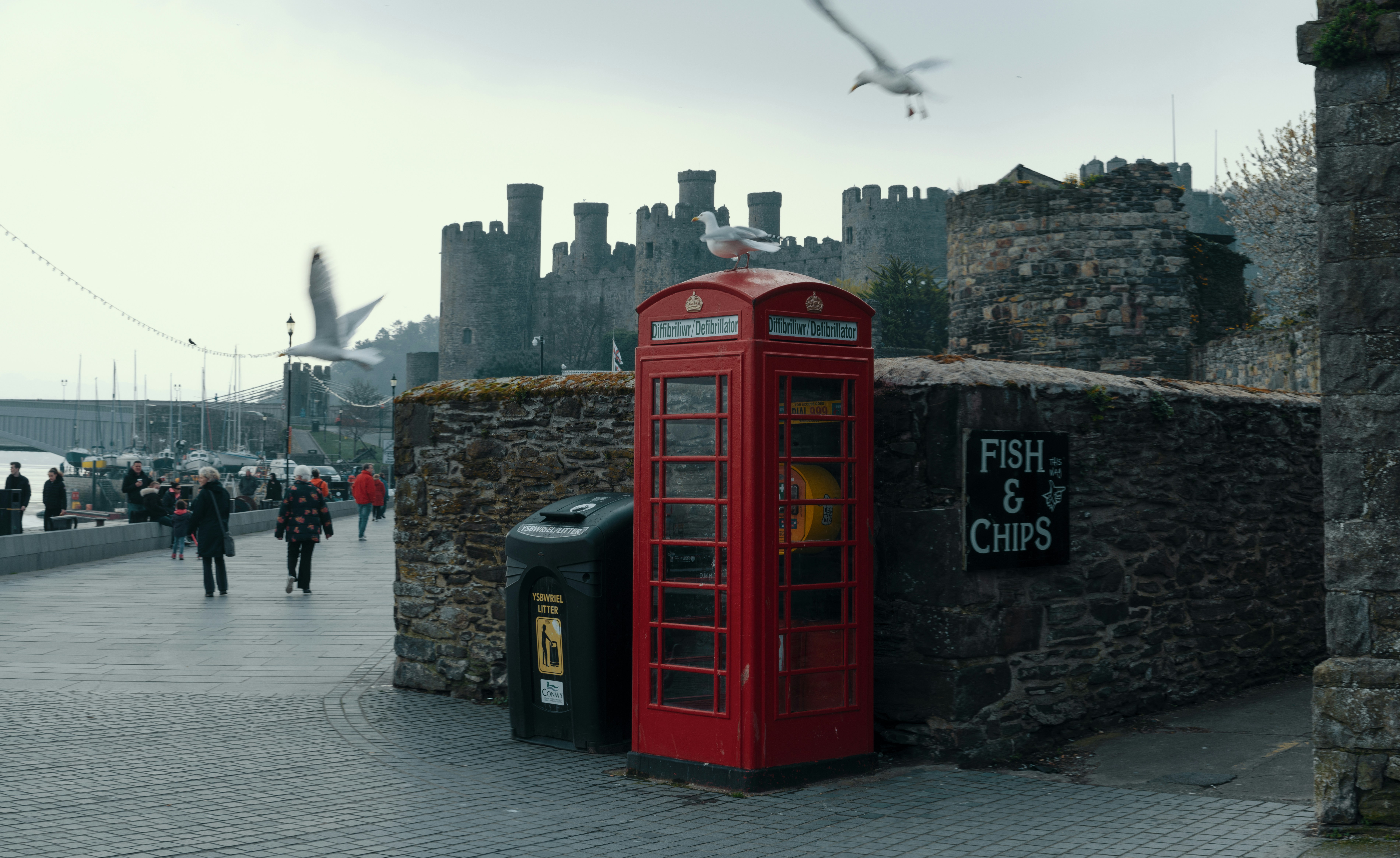 red telephone booth near brown concrete building during daytime