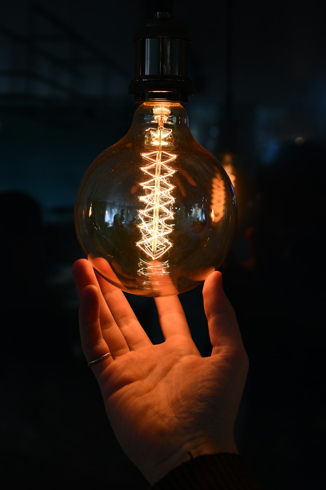 person holding clear glass bulb
