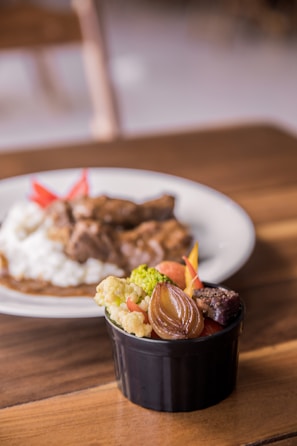 Close-up of a rustic bowl filled with colorful roasted vegetables and herbs.