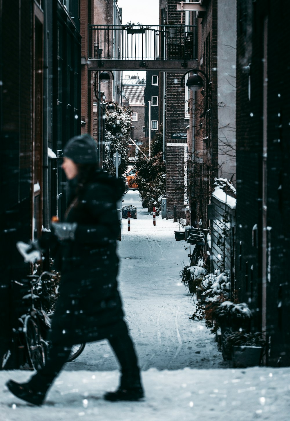 person in black jacket walking on street during daytime