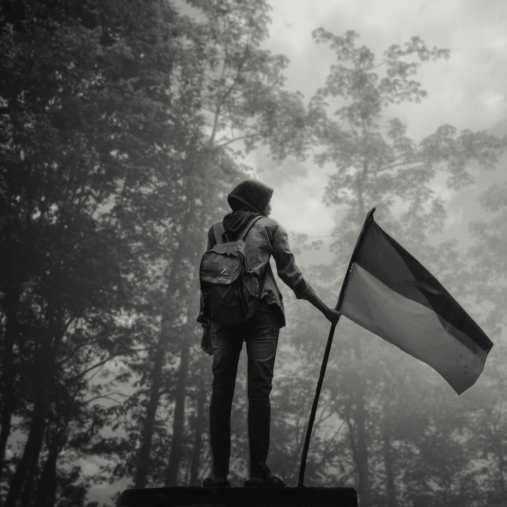 man in black jacket holding yellow and green flag