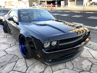 A sleek car with custom rims and tinted windows parked outdoors.