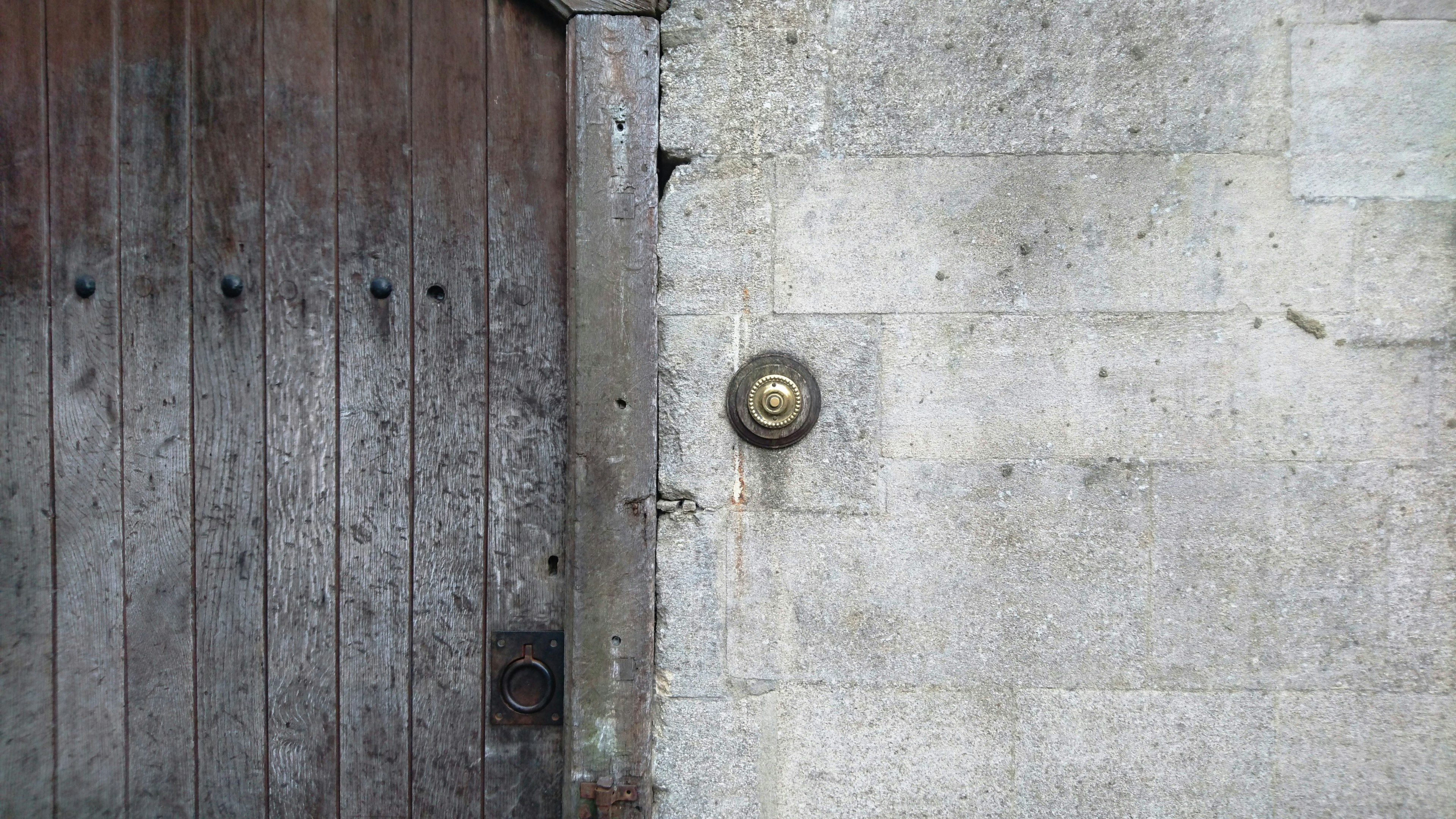 A doorbell. Plain, simple and surrounded by beautiful textures.