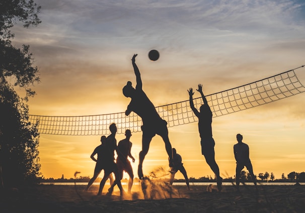 silhouette of people playing basketball during sunset