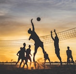 silhouette of people playing basketball during sunset