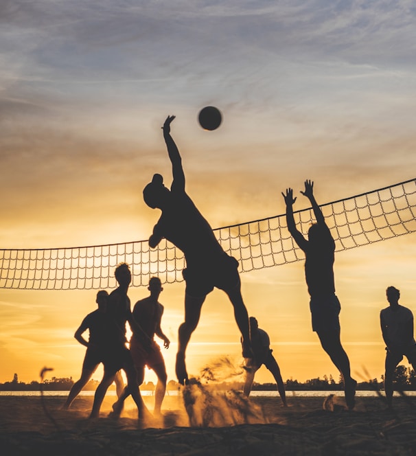 silhouette of people playing basketball during sunset