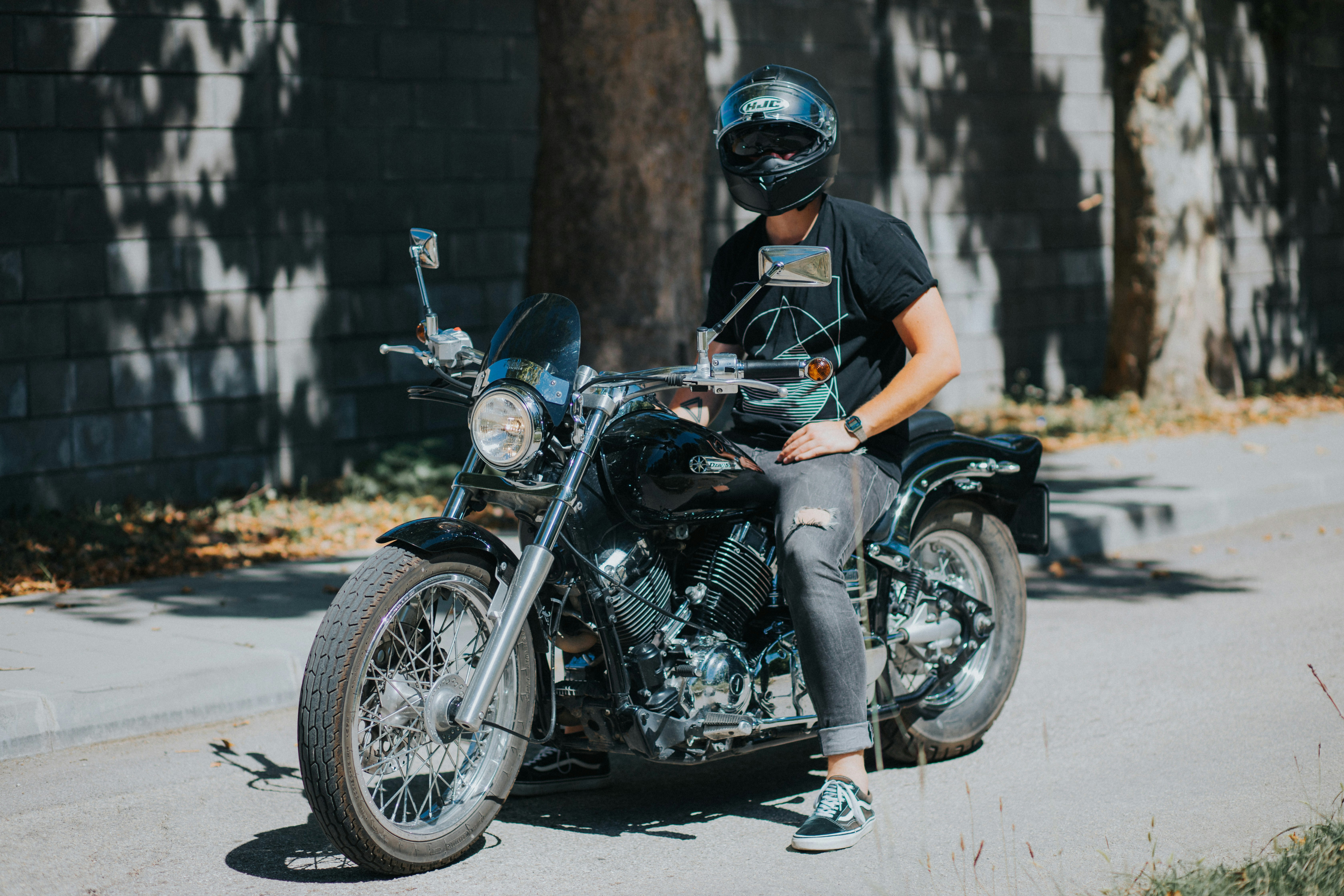 man in orange t-shirt and black helmet riding black motorcycle