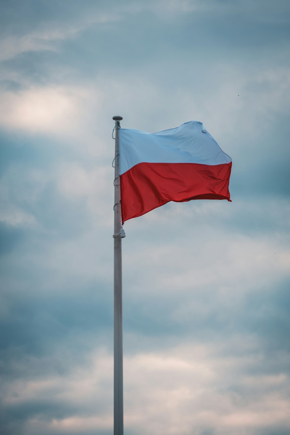 blue and white flag under white clouds