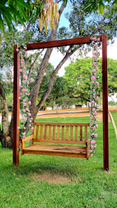 brown wooden bench under green and pink leaf tree