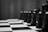 A monochrome image of a chessboard with a close-up focus on chess pieces. The pawns and other pieces are positioned on the checkered board, creating a sense of strategy and contemplation.