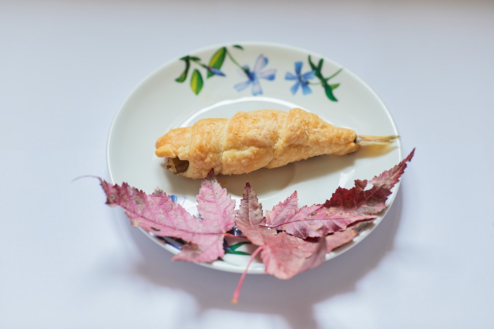 bread on white and red floral ceramic plate