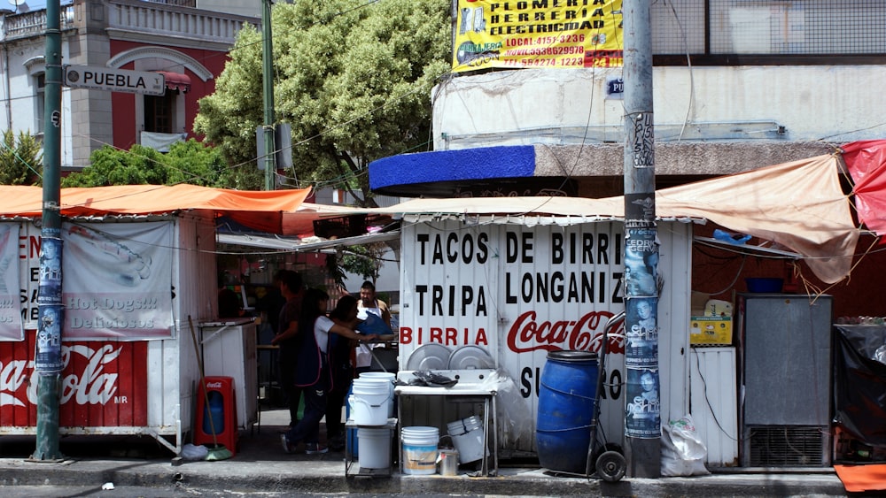 Personas paradas cerca de letreros blancos y azules durante el día