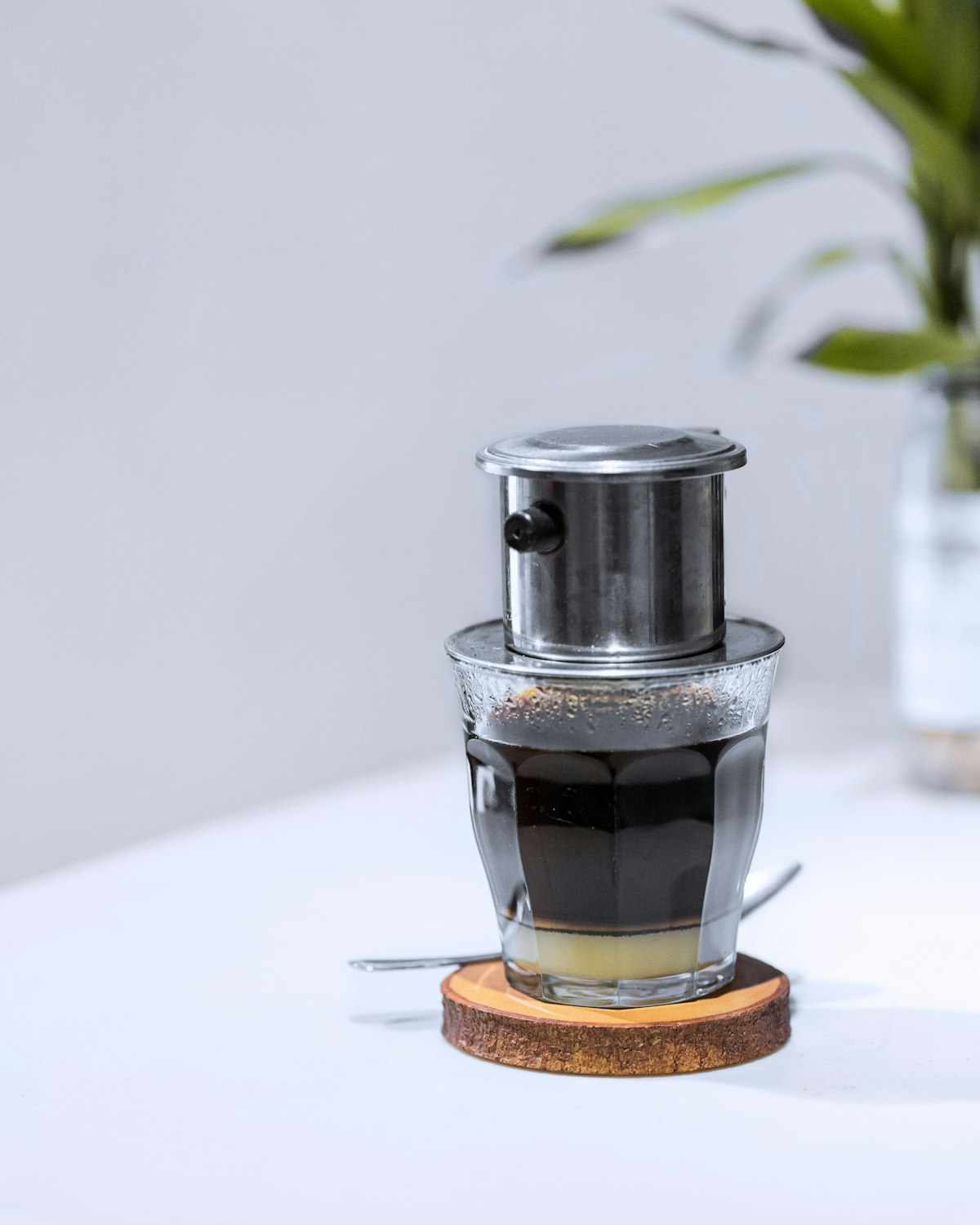 Phin cà phê nhỏ giọt xuống lớp sữa đặc trong ly