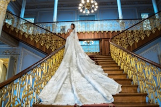 woman in white wedding dress standing on staircase