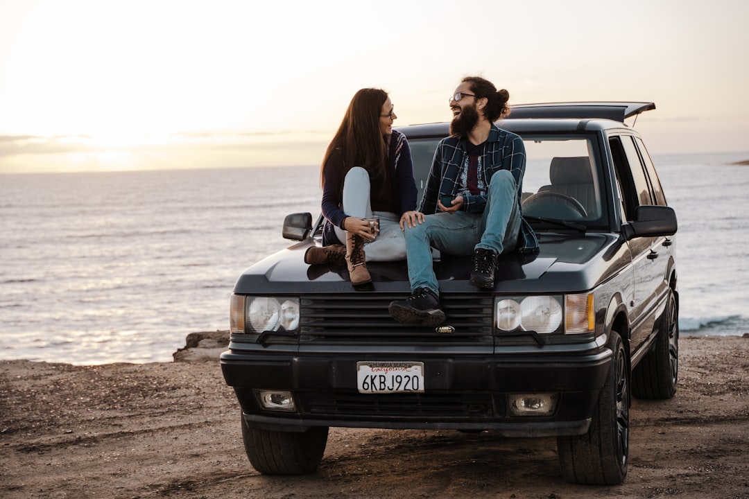 2 women sitting on black car