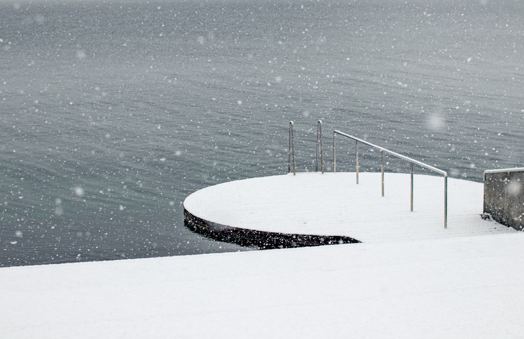 white and black surfboard on body of water