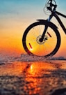 black bicycle on brown sand during sunset