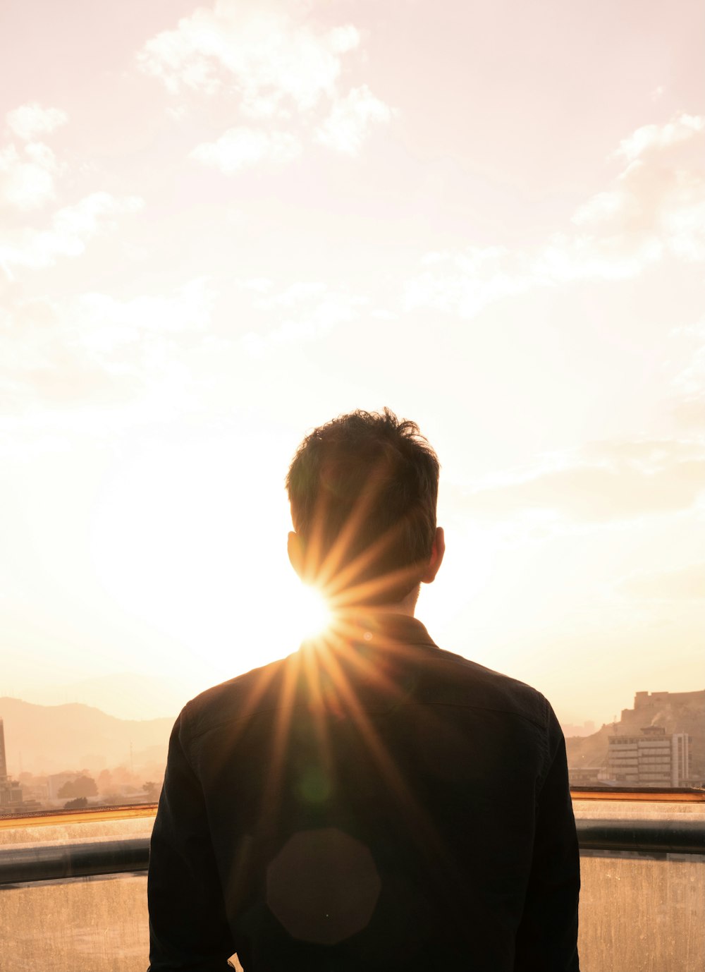 man in black shirt standing during sunset