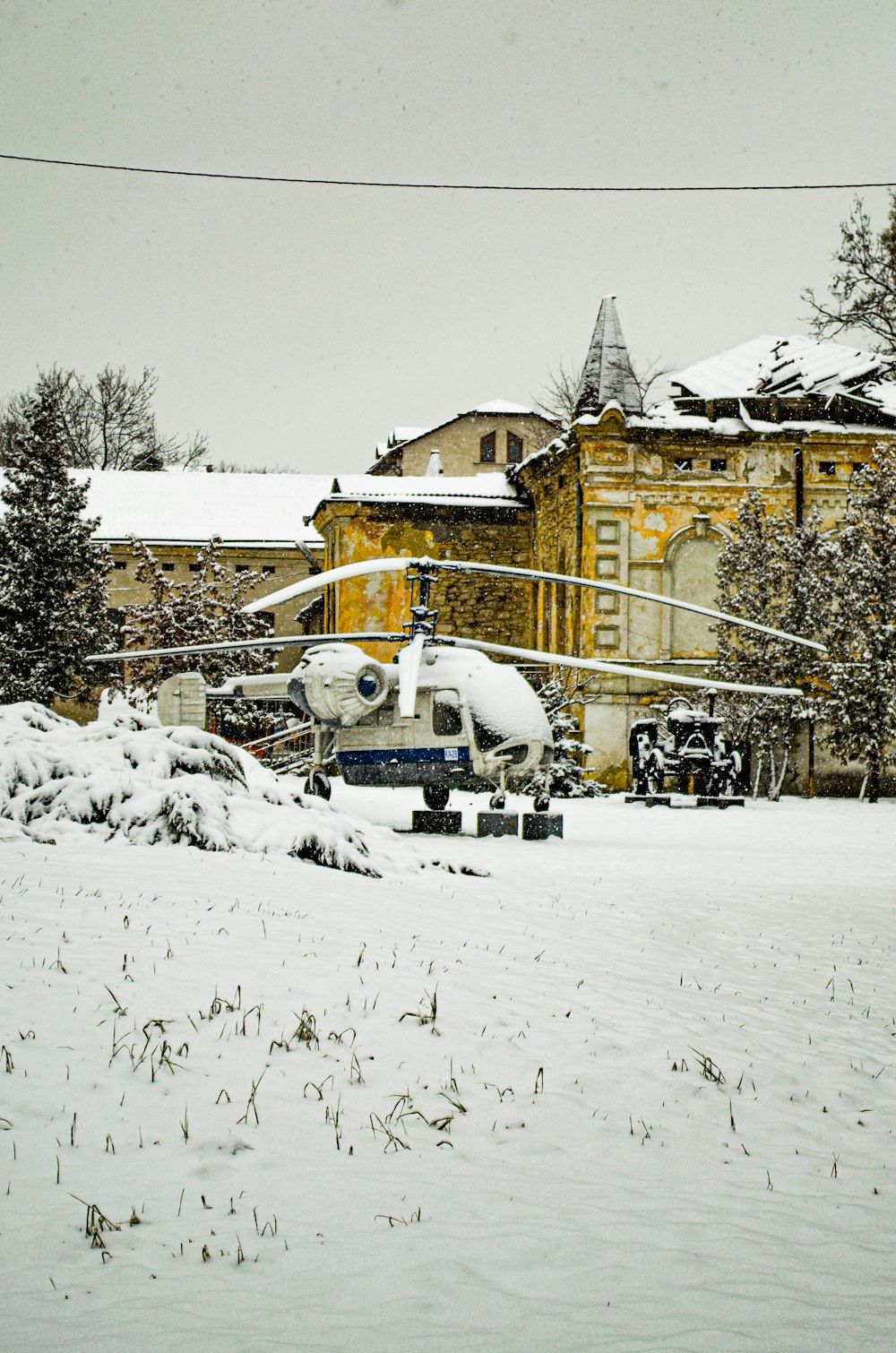 white car on snow covered road near brown building during daytime