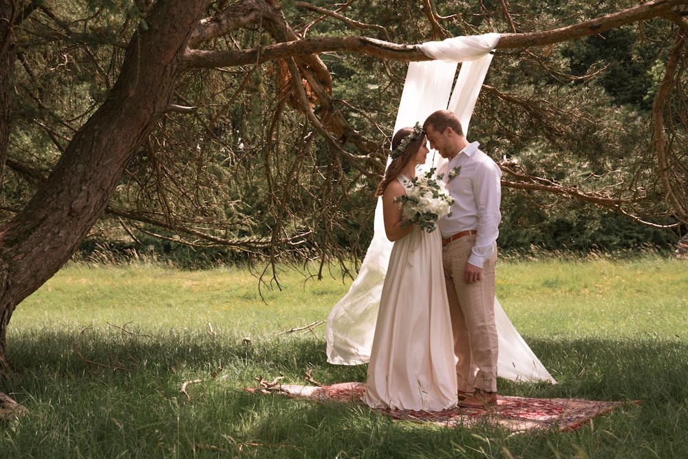 bride and groom kissing under brown tree