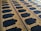 An ornate carpet featuring intricate designs with symmetrical patterns and arabesque motifs. The carpet is predominantly dark blue with gold and red embellishments along the borders and within the design elements.