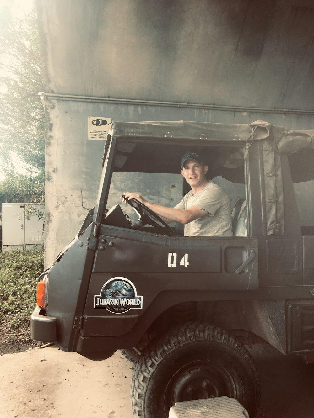 man in brown shirt driving black and red jeep wrangler