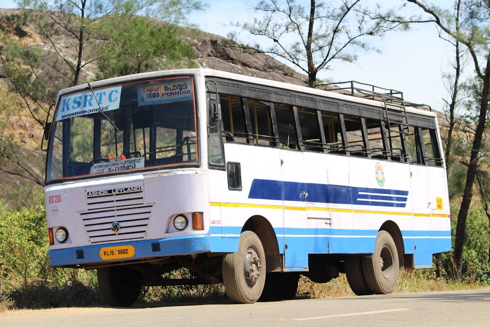 white and blue bus on brown soil