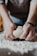 person holding white dough on brown wooden table